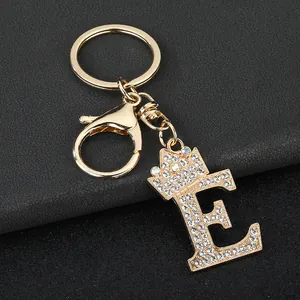 Detail view of gold crown letter E keychain with sparkling white rhinestones