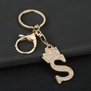 Close-up of golden zinc alloy keychain with rhinestone letter S and crown charm
