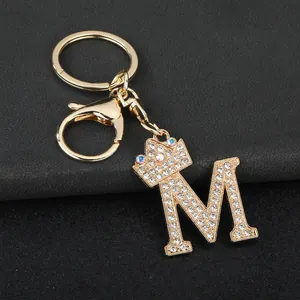 Detailed view of gold rhinestone letter M keychain with a sparkling crown charm