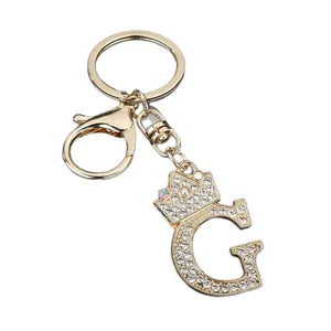 Elegant gold alloy letter G keychain decorated with rhinestones and crown pendant
