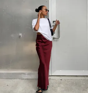 Élégante jupe midi en satin bordeaux avec un t-shirt blanc court et des sandales