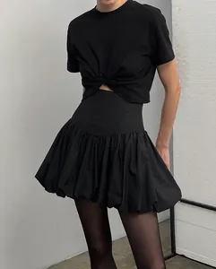 Detail view of the black high-waisted bubble skirt featuring a pleated voluminous hem design.