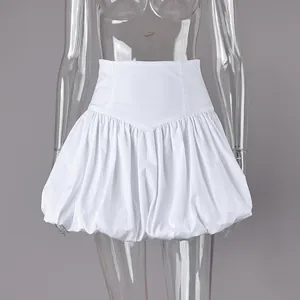 Detail view of the high-waisted white cotton bubble skirt with elegant pleated bud hem design