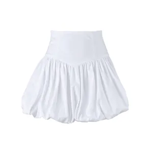 Close-up detail of a white high-waisted cotton bubble skirt featuring elegant pleated texture