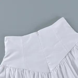 Detailed close-up of the high waistband and hidden zipper on this white cotton skirt