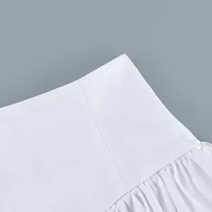 Close-up view of the high-waisted pleated cotton skirt showing fabric detail