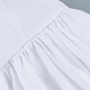 Close-up of pleated waist detail and white cotton fabric texture on a skirt