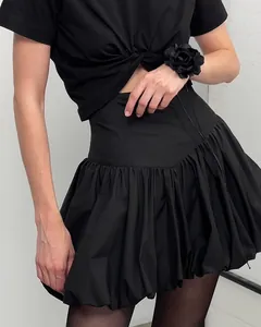 Detail of a chic black high-waisted cotton bubble skirt for a slimming fashion look.