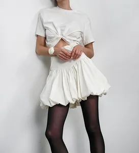 Fashionable detail showing a white cotton bubble puff skirt paired with a twisted t-shirt