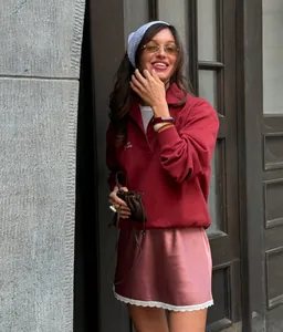 Detail of pink satin mini skirt with white lace hem worn in a street style outfit.