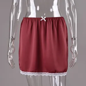 Detail view of burgundy satin mini skirt with lace hem and waist bow accent