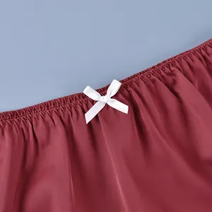 Detailed close-up showing the elasticated waistband and white bow on a wine red skirt