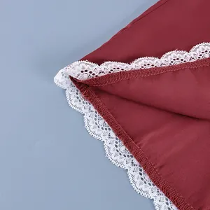Detailed close-up of white scalloped lace trim on a burgundy high-waisted skirt hem.