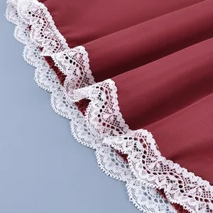 Detailed close-up showing the intricate white lace hem on a dark red skirt fabric