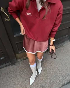 Detail of a rose satin skirt with white lace trim paired with a burgundy sweatshirt