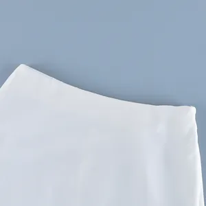 Close-up detail of the waistband and hidden side zipper on a white high-waist sheer skirt