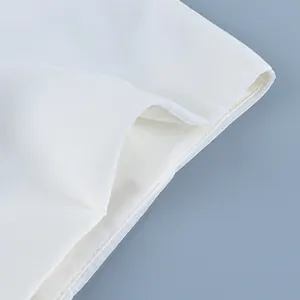 Detail shot of white sheer chiffon fabric and fine stitching on high-waisted skirt
