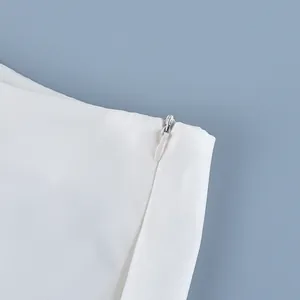 Detail view of a high-waist white skirt showing the smooth concealed side zipper mechanism.