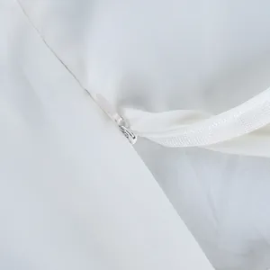 Detailed view showing the invisible zipper and fine fabric texture of white skirt