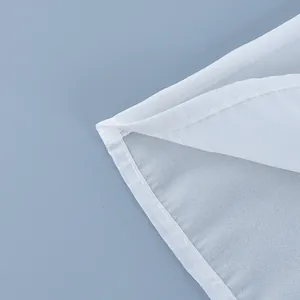 Macro view of the high-quality hem stitching on a white sheer high-waisted skirt