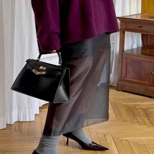 Elegant sheer black high-waisted midi skirt perfect for a stylish and modern commute look.