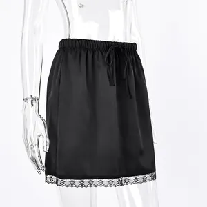 Detail of black satin mini skirt with elegant lace hem and drawstring waist