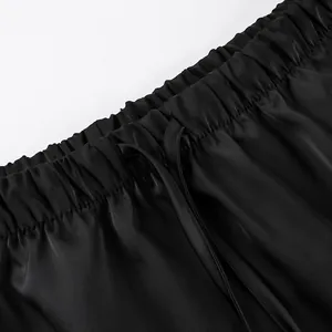 Close-up detail of elastic waistband and drawstring on a black satin skirt