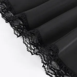 Detailed macro view showing the intricate black lace hem on smooth satin skirt fabric