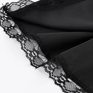 Close-up detail of a black satin skirt featuring elegant floral lace trim at the hem