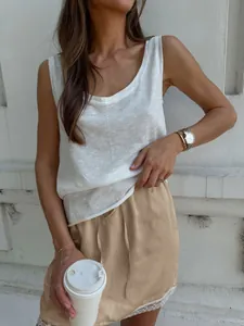 Close-up detail of a minimalist beige satin skirt featuring elegant white lace trim at the hemline