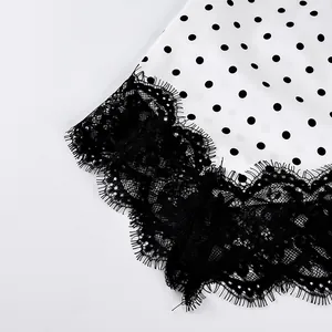 Close-up view showing the intricate black eyelash lace trim on a white polka dot skirt fabric.