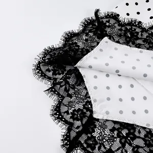 Close-up detail of black eyelash lace trim and white polka dot fabric on a skirt