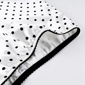 Detailed view of polka dot skirt waist with scalloped lace trim and size M tag
