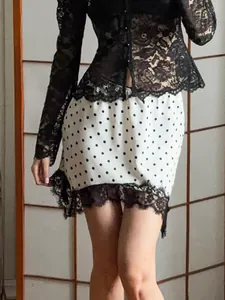 Elegant white polka dot short skirt with black lace trim and irregular hem for summer