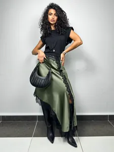 Detailed view of an asymmetrical olive green satin skirt featuring delicate black lace trim