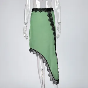 Detail of asymmetric green satin skirt with intricate black lace trim hemline