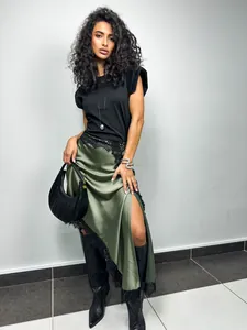 Detailed view of women's asymmetric green satin midi skirt with black lace trim