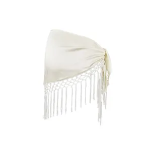 Detailansicht eines eleganten cremefarbenen Satin-Wickelrocks mit Fransen und Bindegürtel