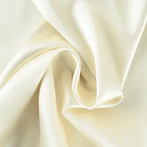 Detaillierte Nahaufnahme von cremeweißem Satinstoff mit elegantem Glanz und Textur