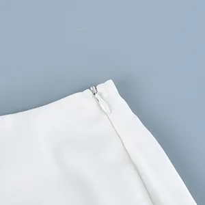 Gedetailleerde weergave van de verborgen ritssluiting op een witte elegante rok
