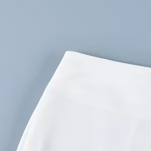 Gedetailleerde weergave van de witte stof van hoge kwaliteit en naadloze taille van de rok