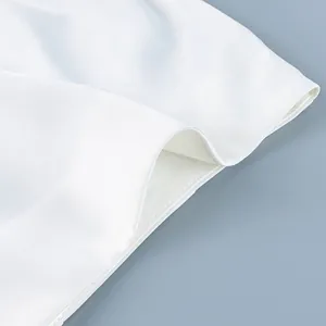 Gedetailleerde close-up van witte satijnen stof met strakke stiksels en gladde textuur.