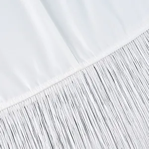 Gedetailleerde macro-opname van elegante witte franjes aan een stijlvolle lange rok