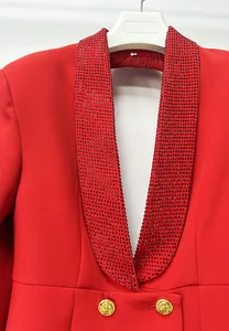 Dettaglio del collo a scialle con strass rossi su un abito blazer di lusso con scollo a V