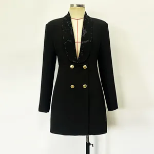 Dettaglio di un abito blazer nero con collo a scialle in strass e bottoni dorati.