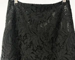Vista detallada de la intrincada textura de encaje floral negro en esta falda elegante