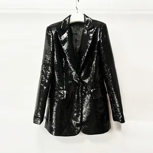 Close-up detail of a glamorous black sequined blazer jacket with shimmering metallic finish
