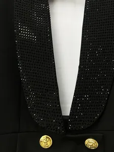 Primo piano di un abito blazer nero con collo a scialle in strass e bottoni d'oro