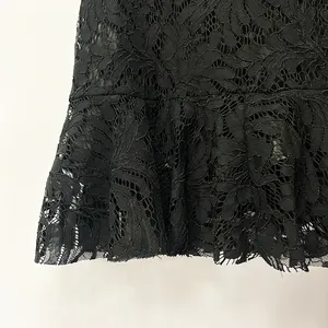 Primer plano detallado de la tela de encaje negro con un diseño de dobladillo de volante