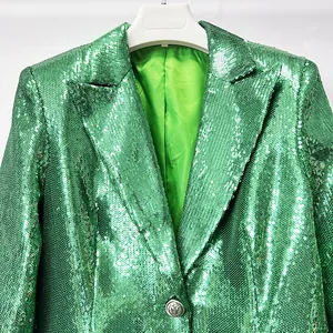 Close-up detail of a vibrant green sequin blazer with shimmering texture and notch lapel